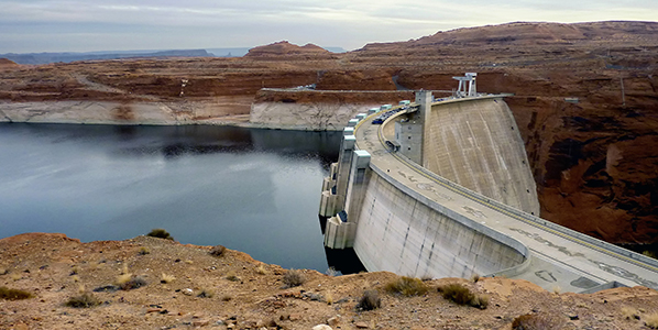 Glen Canyon Dam from the side with low water behind it.