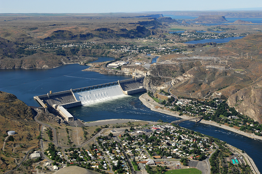 Aerial view of Grand Coulee Dam releasing downstream an unusually large and late spring time water flows of over 200,000 cfs. Broken out, it’s  33,800 cfs, over the spillway and 167,000 cfs through the hydropower generators.