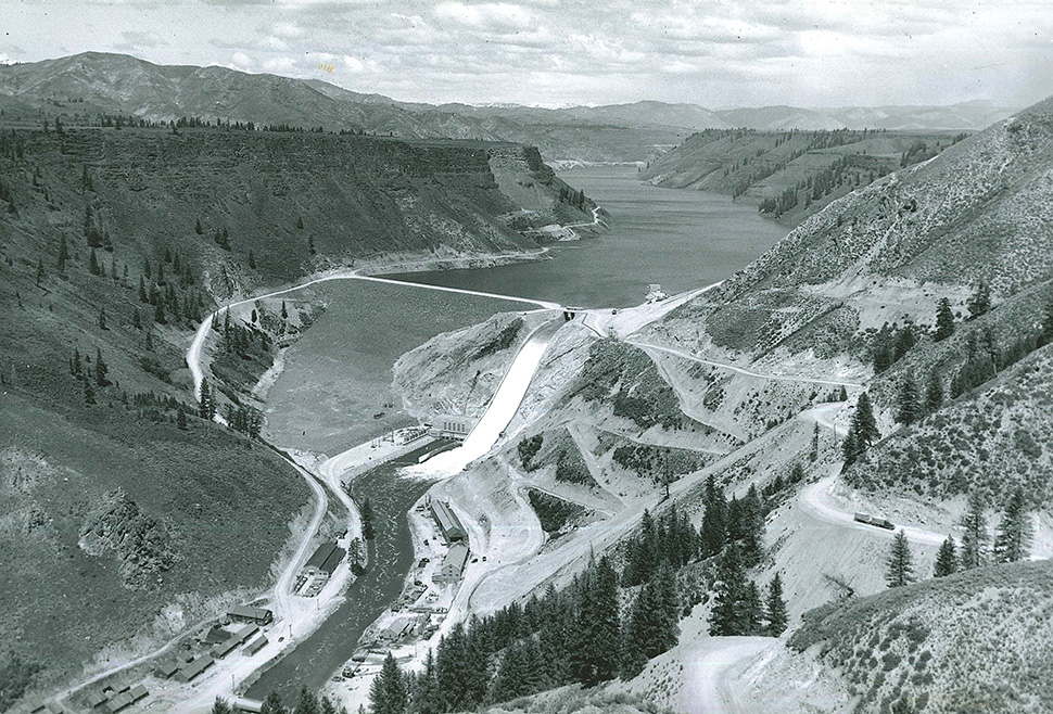 Historic photo of Anderson Ranch Dam and Reservoir taken from a hill looking down at the dam.