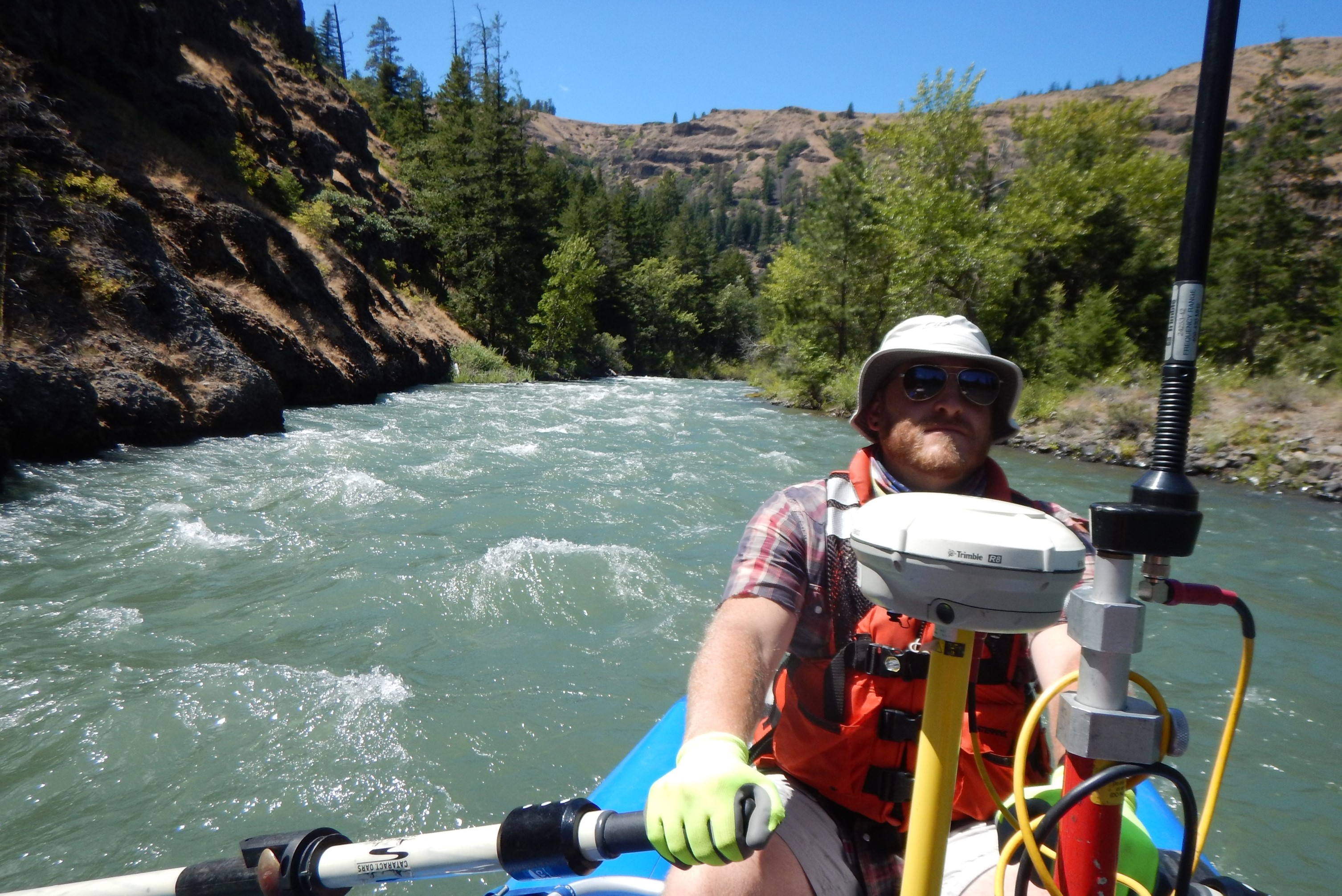 Staff Employee Rowing Surveying Boat in River Rapids