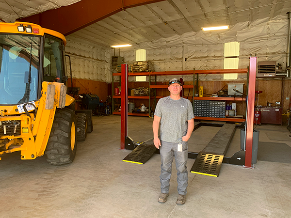 Robert Weaver, Flaming Gorge Maintenance Supervisor, standing in front of the new auto lift that was installed in the heavy equipment shed.