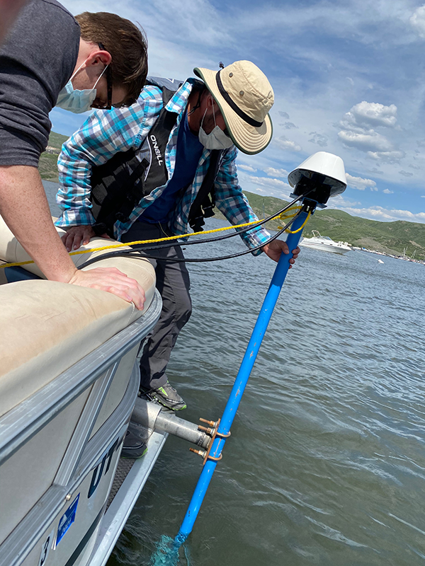 Jacob Allen (CUWCD) and Josh Kresge (Reclamation) placing the sonar head held by a mounting bracket into Jordanelle Reservoir, Utah.