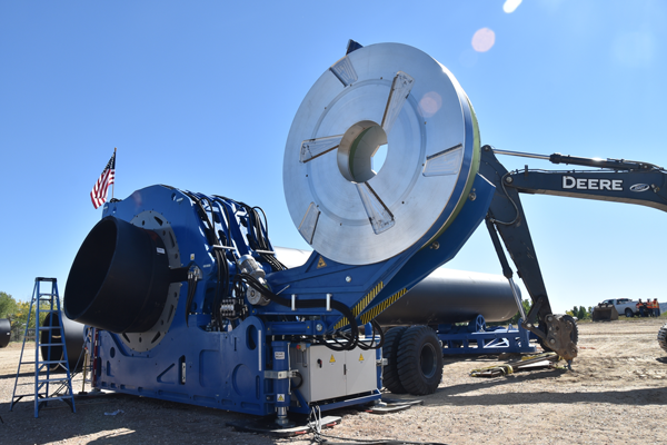 Workers at the Steinaker Service Canal Pipeline Project site operate a Tecnodue fusing machine to fuse a 15-degree elbow onto a section of an 84-inch-diameter HDPE pipe.