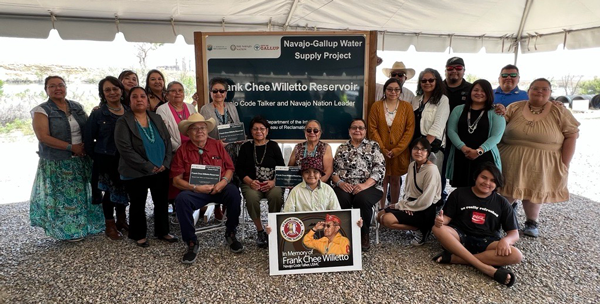 Willetto family celebrating the unveiling of the new Frank Chee Willetto Reservoir, new reservoir sign displayed in the back