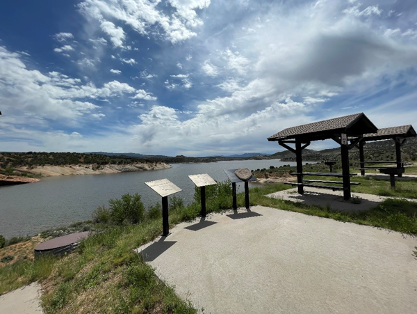 Red Fleet Reservoir overlook with information boards in the foreground and covered picnic tables in the background