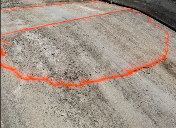 Bright orange spray paint marks the area where the spillway's concrete needed to be repaired