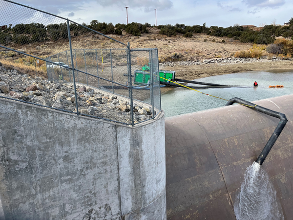 Water flowing into Spillway during sandbag placement over pipe